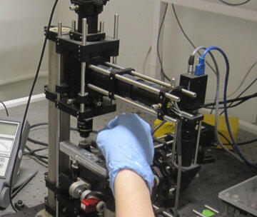 oil being applied to lens of Optical trap set-up on a diode laser