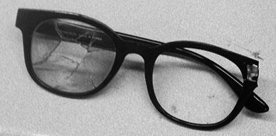 glasses with right lens and temple bar that have been blown away. The left lens is shattered