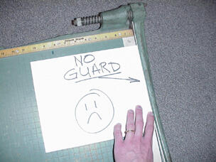 a hand on a paper cutter with no finger guard