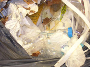 Combined-waste trash bag containing sharps